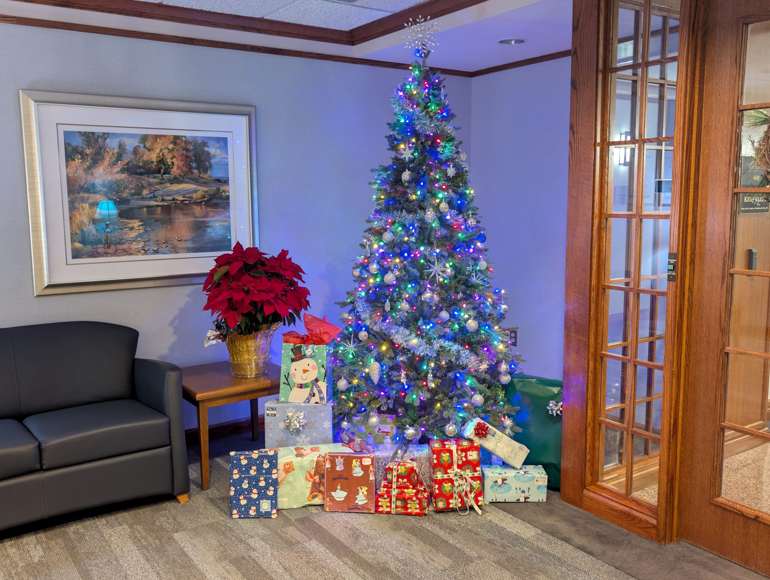 Decorated holiday tree with wrapped gifts at Kemp Klein, representing the firm’s participation in Oakland County Foster Closet’s 2025 Holiday Initiative for Children.